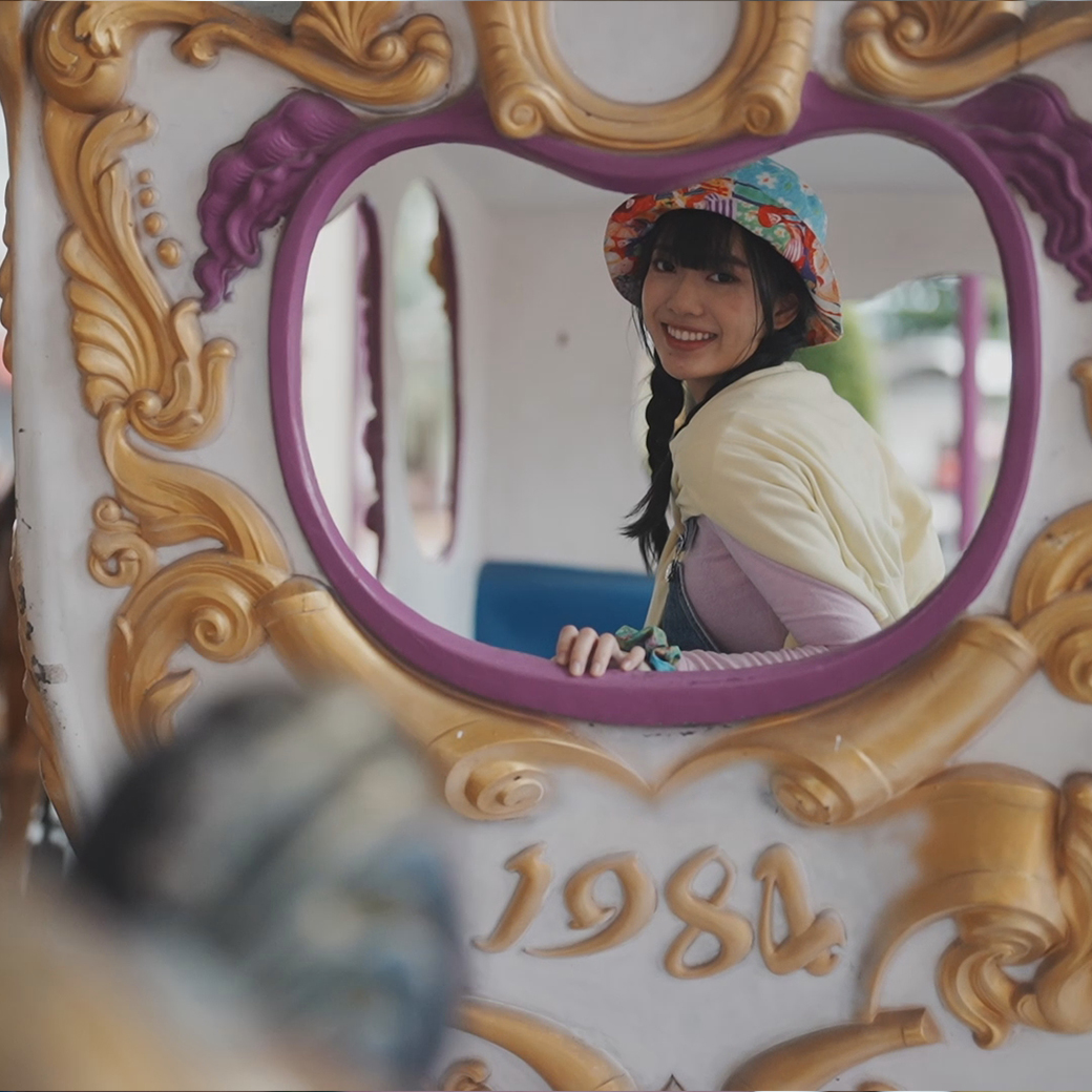 View of girl in the carriage window on a merry-go-round 